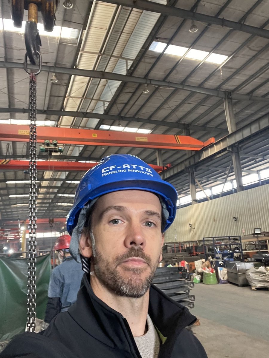 Matthew in a hard hat at a manufacturer in China